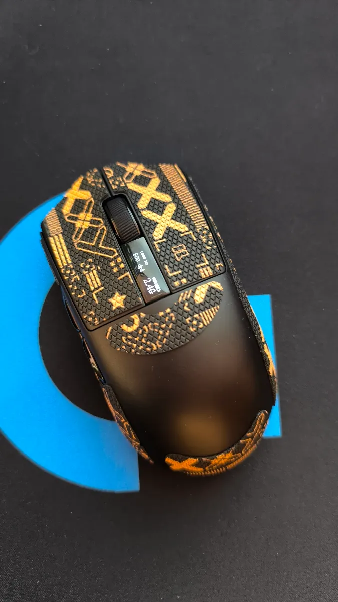 Mouse gamer Furycube G9 Pro negro con grips personalizados y pantalla digital en un setup real