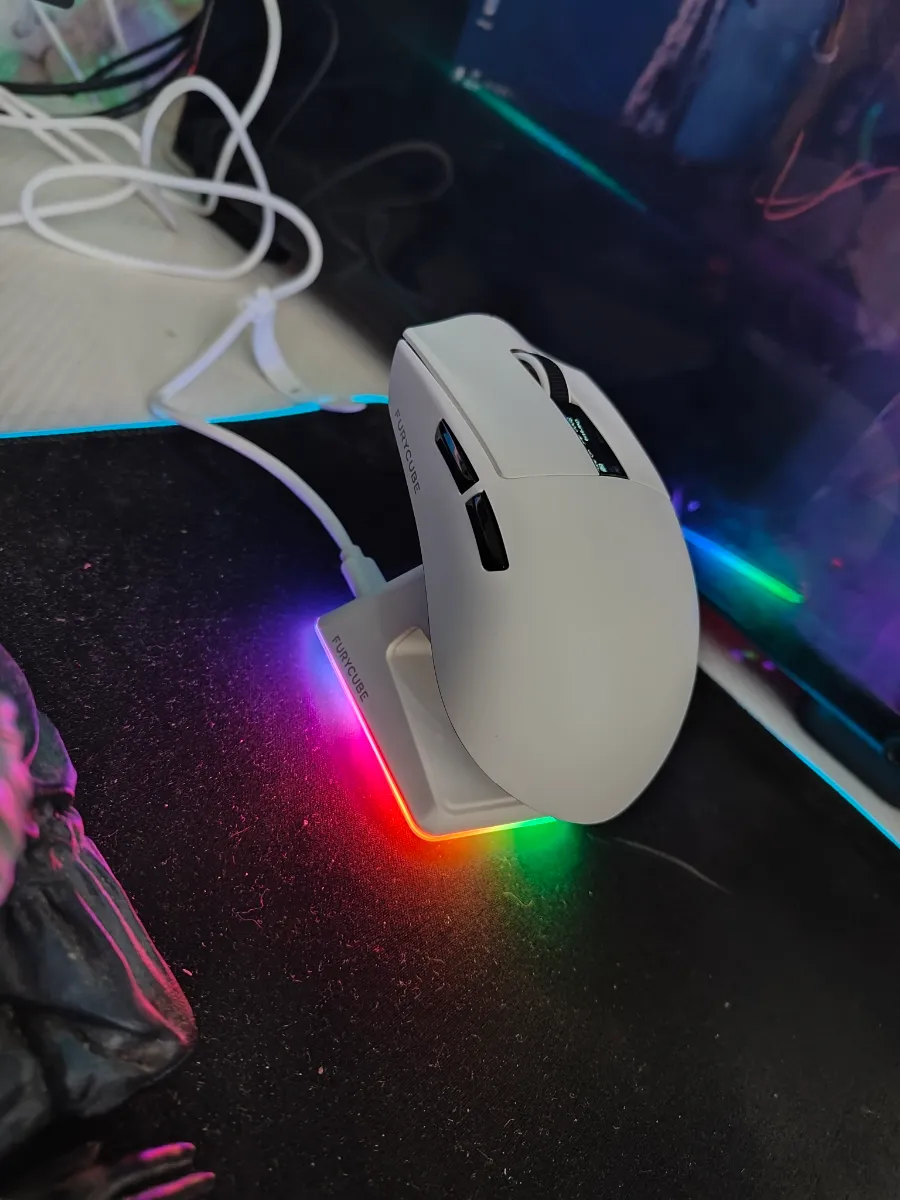Mouse gamer Furycube G9 Pro blanco sobre su base de carga RGB en un setup real