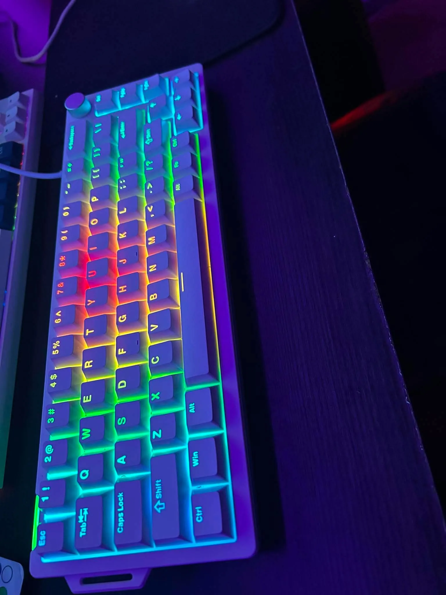 Primer plano de un teclado mecánico blanco con iluminación RGB de un cliente
