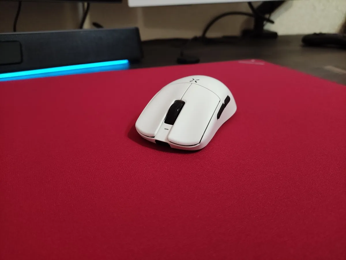Primer plano de mouse blanco sobre mouse pad Furycube Zora rojo
